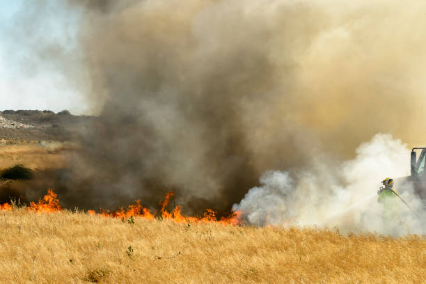 istock Smoke and Flames From Grass Wildfire With Unrecognizable Firefighter 1023788224