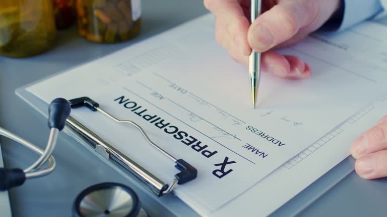 Male Doctor Writing Rx Prescription On Clipboard At Desk 4K