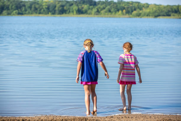 istock Two Girls Walking Into Water at Beach 1023832148