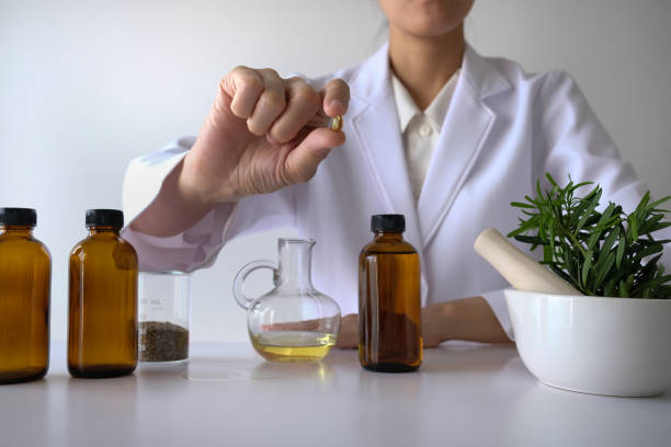 medico donna scienziato fare erboristeria in laboratorio con foglie di erbe integratori vitaminici minerali ricerca di trattamento alternativo. - chinese medicine homeopathic medicine herbal medicine doctor foto e immagini stock