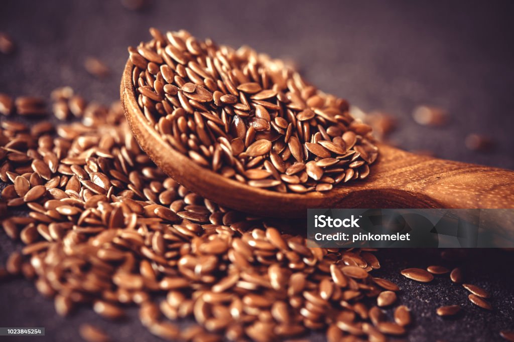 Close up flax seed in wooden spoon , super food with hight of a fiber nutrient and anti inflammatory omega-3 fatty acids Close up flax seed in wooden spoon , super food with hight of fiber nutrient and anti inflammatory omega-3 fatty acids Flax Seed Stock Photo