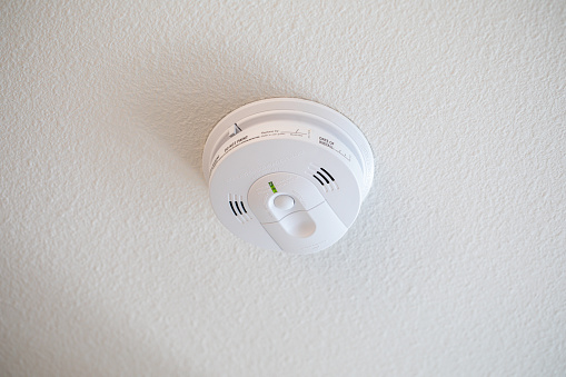 Carbon monoxide and smoke detector on a white ceiling