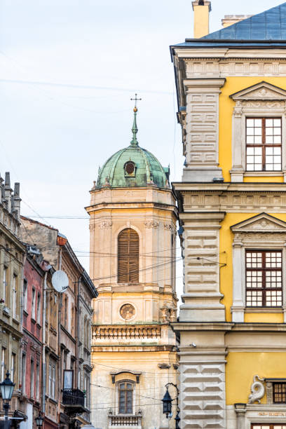 dominican church cityscape with dome in historic ukrainian polish lvov city at sunset, golden hour sunlight, nobody, buildings, alley street in old town - lvov dome summer light imagens e fotografias de stock