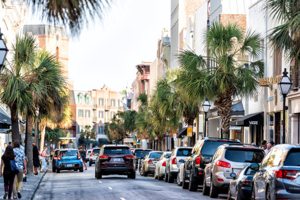 Downtown city King street in South Carolina with people walking in southern town at sunset by shops, restaurants, cars parked on road Charleston, USA - May 12, 2018: Downtown city King street in South Carolina with people walking in southern town at sunset by shops, restaurants, cars parked on road charleston south carolina photos stock pictures, royalty-free photos & images