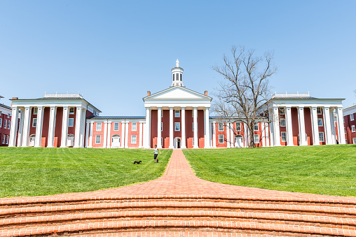 Lexington, USA - April 18, 2018: Washington and Lee University hall in Virginia exterior facade during sunny day with woman walking down, exterior brick architecture
