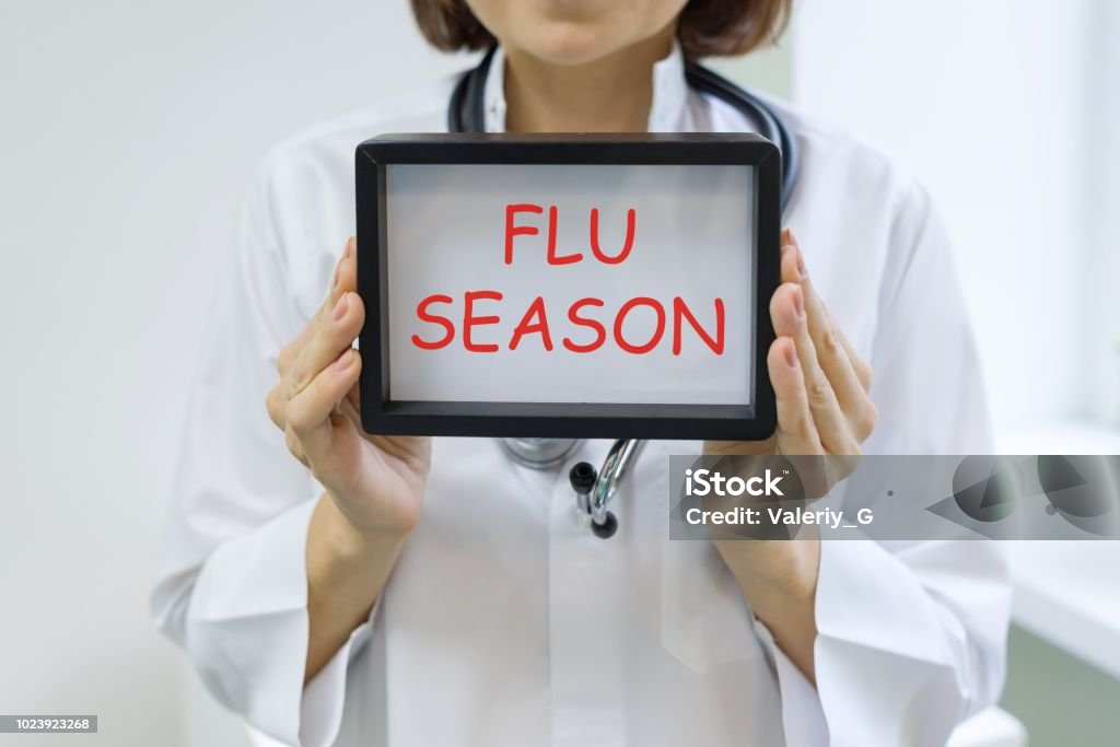 Flu season text in the hands of a female doctor Flu season text in the hands of a female doctor. Cold And Flu Stock Photo