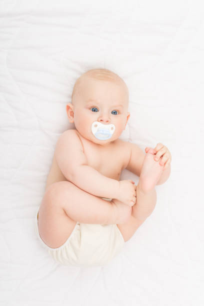 Chico lindo bebé Rubio de ojos azules en pañal con chupete - foto de stock