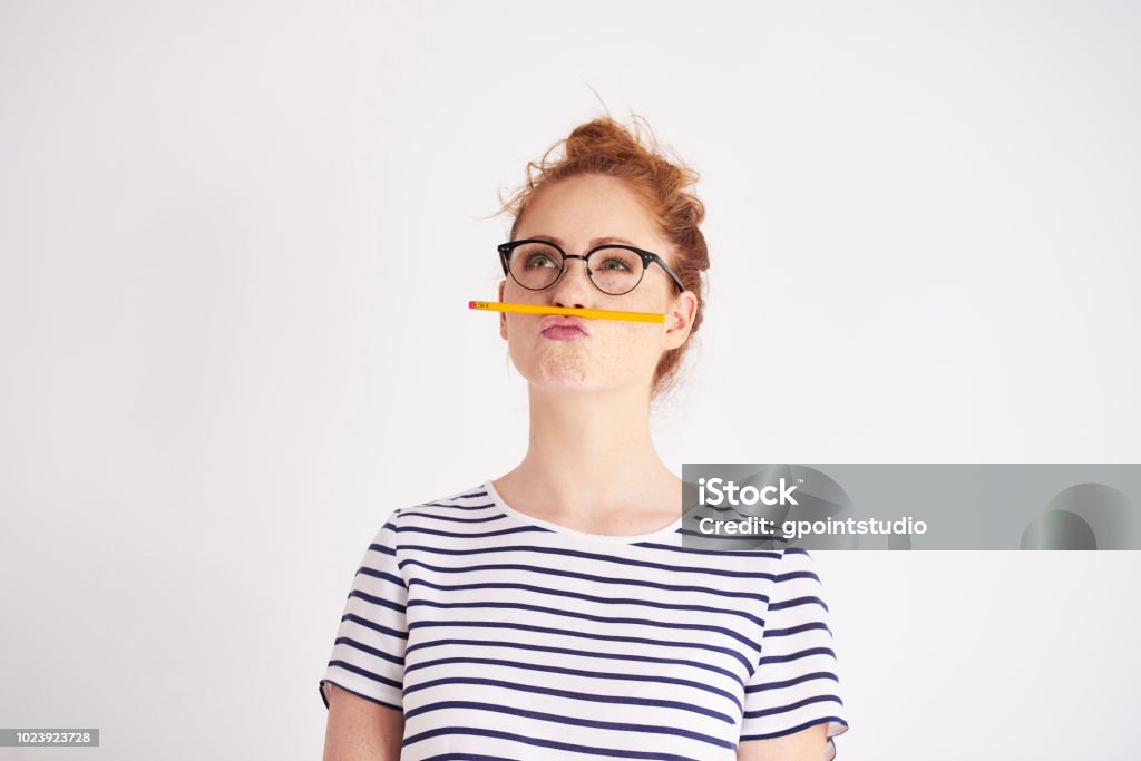 Bored woman having fun with pencil Contemplation Stock Photo