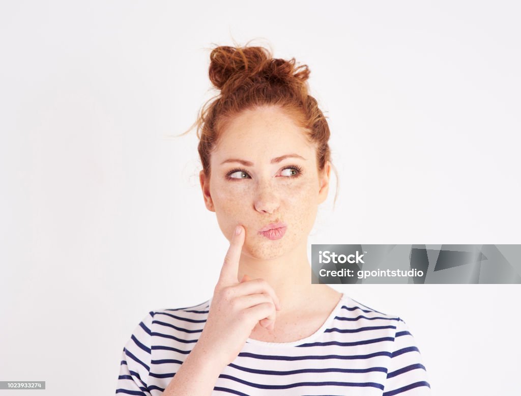 Woman with hand on chin thinking at studio shot Women Stock Photo
