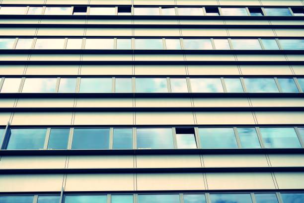 istock Modern office building on a clear sky background. Retro stylized colorful tonal filter effect 1023936400