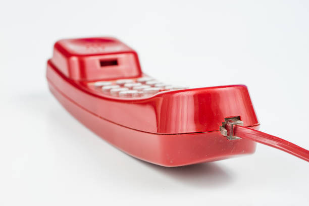 Old red phone with a handset. A telephone set from the nineties. White background.