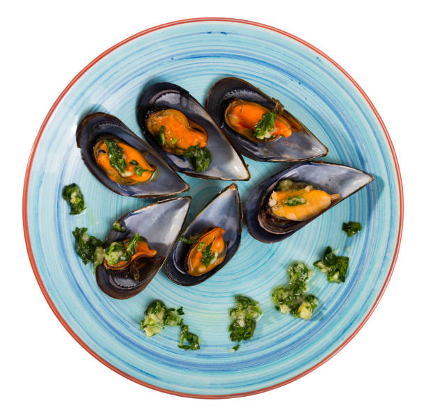 Image of mussels with sauce on the plate. Isolated over white background