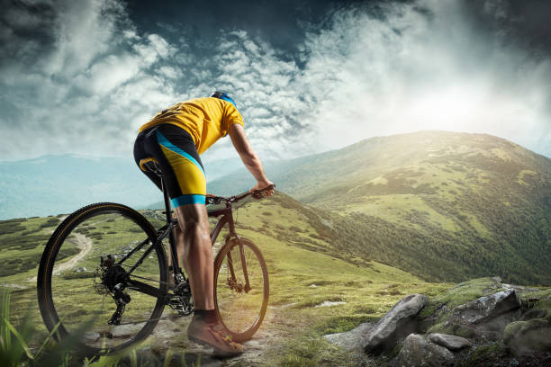 The young fit man in helmet conquering mountains on a bicycle The young fit man in helmet conquering mountains on a bicycle. The bike, nature, bicycle, sport, cycle, extreme, lifestyle, adventure and sport concept red white blue bike stock pictures, royalty-free photos & images