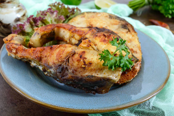 istock Large steaks of grilled fish with lettuce on a plate. 1023959894