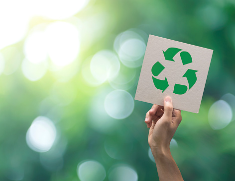 Mano recicla símbolo en fondo verde bokeh. Eco y salvar el concepto de tierra. photo