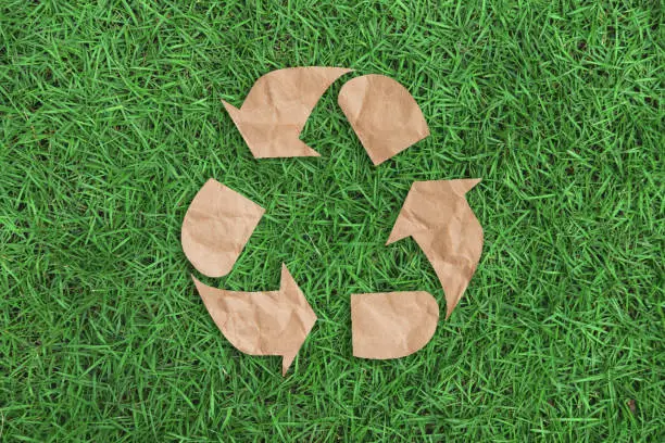 recycle symbol on green grass background top view. eco and save the earth concept.