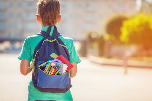 istock Back to school concept. Schoolboy with full backpack go to school. Back view 1023977344