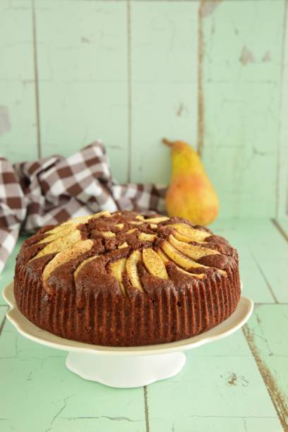 istock chocolate cake with pear on green background 1023980380