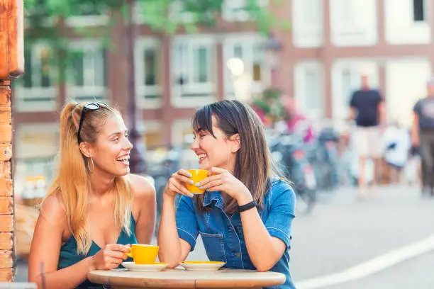Two young Dutch women having a coffee and enjoying their summer evening in Amsterdam