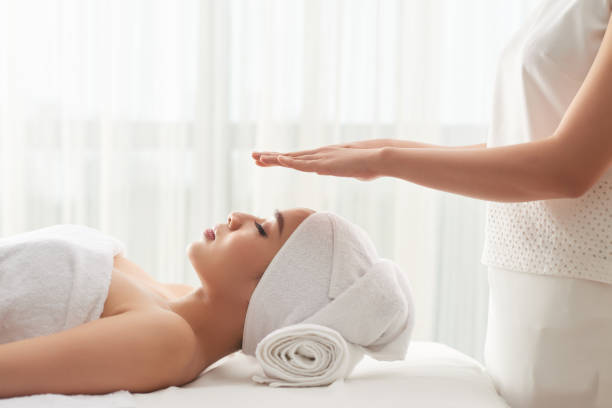 transferring energy - reiki alternative therapy massaging women imagens e fotografias de stock