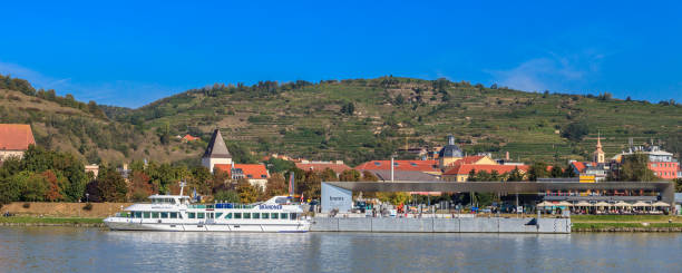Ferry and tourists at the harbor of Krems in the Wachau, an Austrian valley crossed by the Danube river with a picturesque landscape inscribed as \