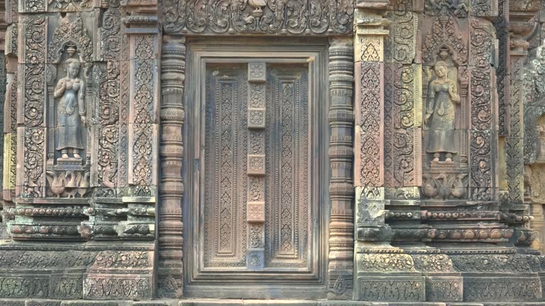 two devata carved in a wall of banteay srei temple