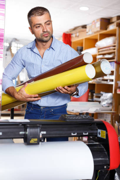 istock male printing worker with rolls of colored paper 1024001176