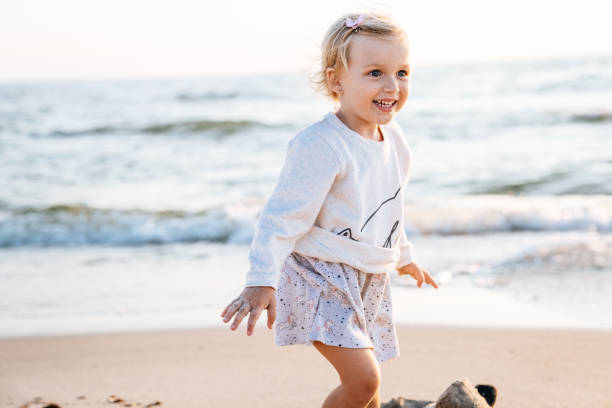 istock Little girl running on the beach 1024013828
