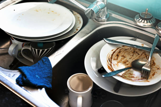 Time to do some washing up: a double sink has both sides crammed with dirty dishes.