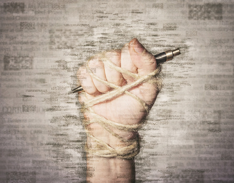 Hand with pen tied with rope, depicting the idea of freedom of the press or freedom of expression. Mixed media.