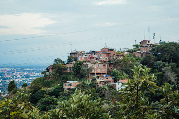 Isolated Colombian Village Shanty town homes in Colombia overlooking other buildings and houses in Colombia surrounded by nature. Copy space available, cloudy day, wires strung across the image. valle del cauca stock pictures, royalty-free photos & images