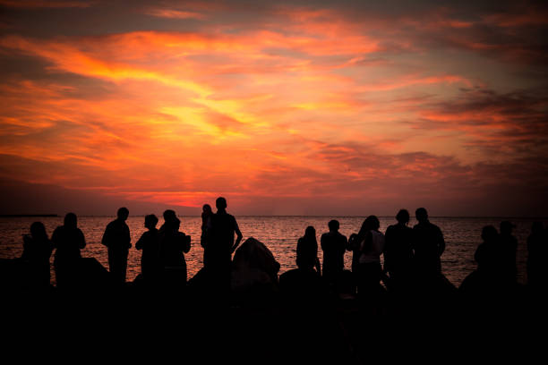 istock Crowd of silhouetted people watching sunrise or sunset 1024040256