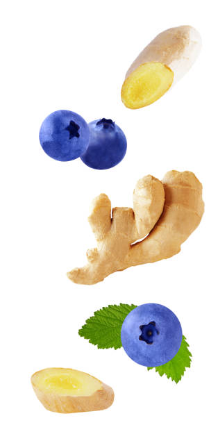 Flying blueberry fruits and ginger root isolated on white