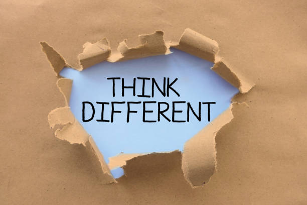istock Think different advice handwritten on white page,  behind torn brown paper or cardboard 1024070638