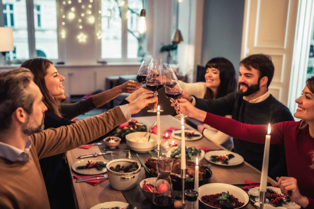 istock happy friends clinking wine glasses at christmas table 1024078046