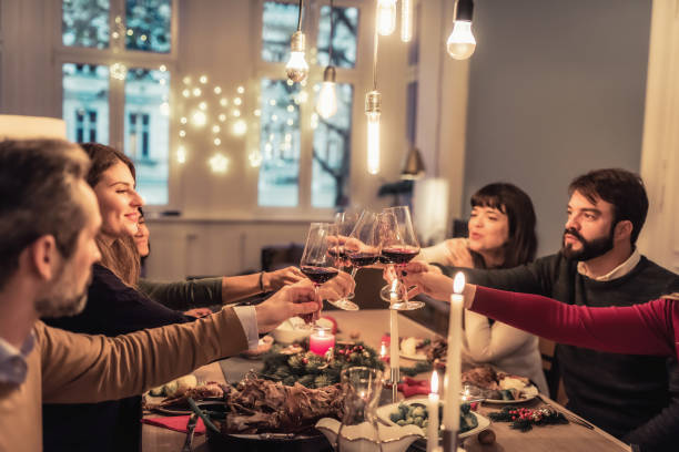 istock happy friends clinking wine glasses at christmas table 1024078592