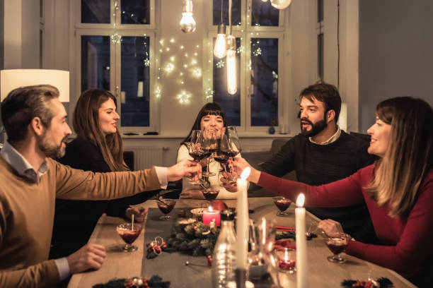 istock happy friends clinking wine glasses at christmas table 1024078962