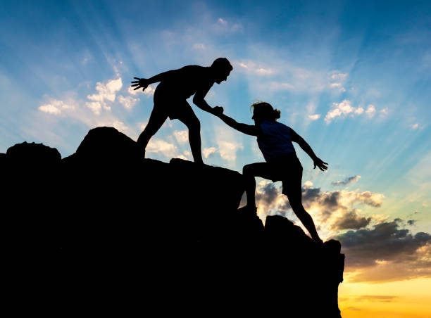 istock Teamwork couple helping hand trust in inspiring mountains 1024088398