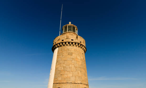 Castle Cornet lighthouse tower in Saint Peter Port - capital of Guernsey - British Crown dependency in English Channel off the coast of Normandy. Castle Cornet lighthouse tower in Saint Peter Port - capital of Guernsey - British Crown dependency in English Channel off the coast of Normandy. guernsey city stock pictures, royalty-free photos & images
