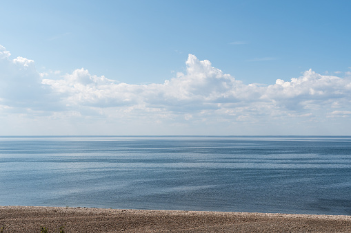 Seascape with calm water and clouds in the sky by the coastline