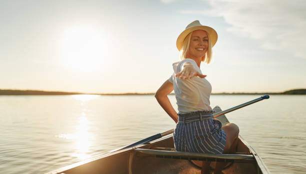 午後遅くに、湖でカヌー笑顔の女性 - canoeing paddling canoe adventure ストックフォトと画像