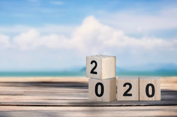 istock Wood cube number 2020 on planks on tropical beach background 1024119552
