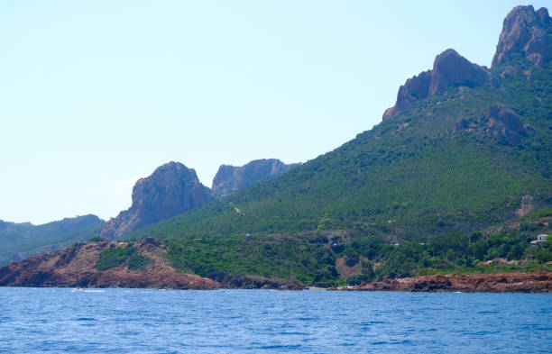 the corniche de l'esterel seen from the sea on board a ferry the corniche de l'esterel seen from the sea on board a ferry that runs along the entire French coast between cannes and saint-raphael corniche de lesterel stock pictures, royalty-free photos & images