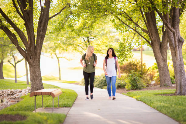 Two female college students on campus are heading to their classes together. They are gearing up for another semester of of learning and education. The two of them are aspiring to new heights at the university. Photograph was taken in Utah, USA.