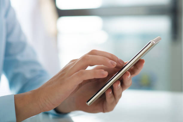 istock Closeup of person browsing on smart phone at table 1024124318