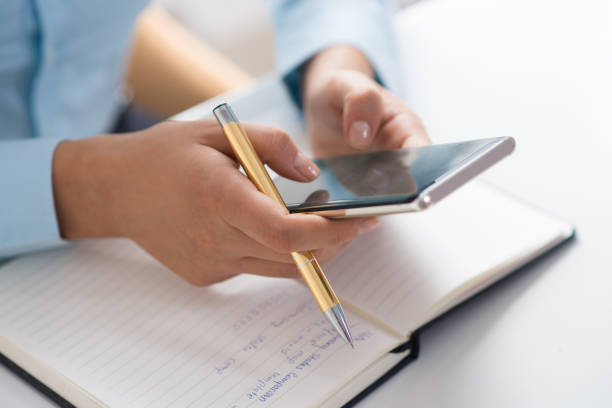 istock Closeup of person using smart phone and working at table 1024124836