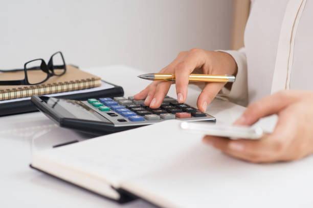 detalle de mujer con calculadora y smartphone - tarifa fotografías e imágenes de stock