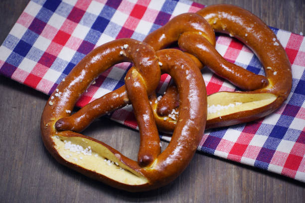 istock Two pretzels with checker cloth on wood table background. 1024128080