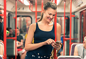 Woman traveling by subway and using phone