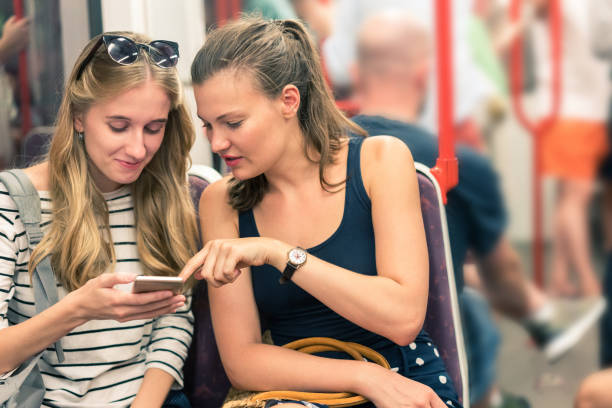 istock Female friends traveling by train using phone 1024129322